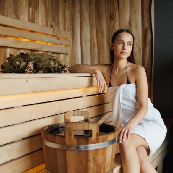 mujer con toalla sentada en una sauna